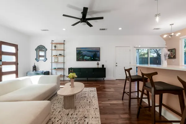 a living room with furniture and a wooden floor