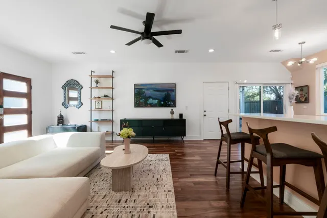 a living room with furniture and a wooden floor