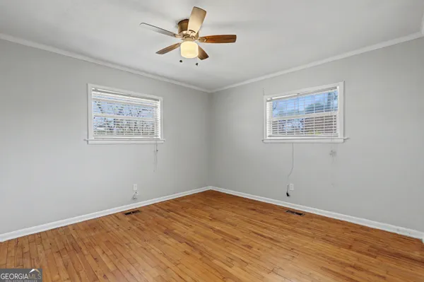 a view of a room with wooden floor and ceiling fan