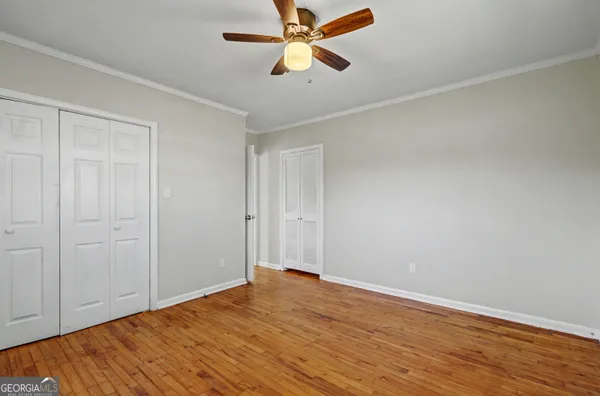 a view of empty room with wooden floor