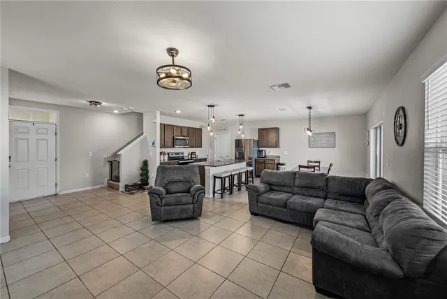 a kitchen with granite countertop a stove a sink a kitchen island with a dining table and chairs