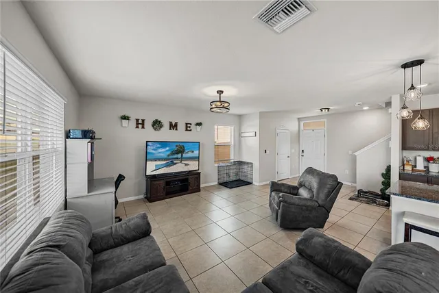 a large kitchen with a table chairs refrigerator and microwave
