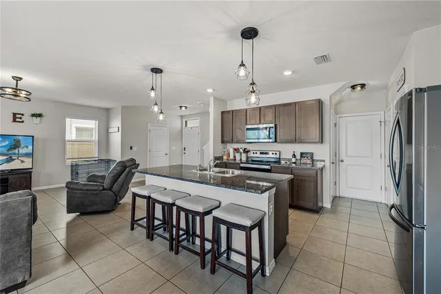 a kitchen with stainless steel appliances granite countertop a stove a sink and a microwave