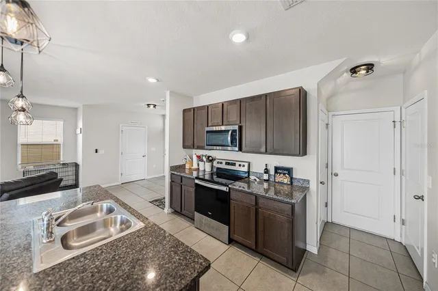 a kitchen with stainless steel appliances granite countertop a refrigerator a sink a stove a washer and dryer