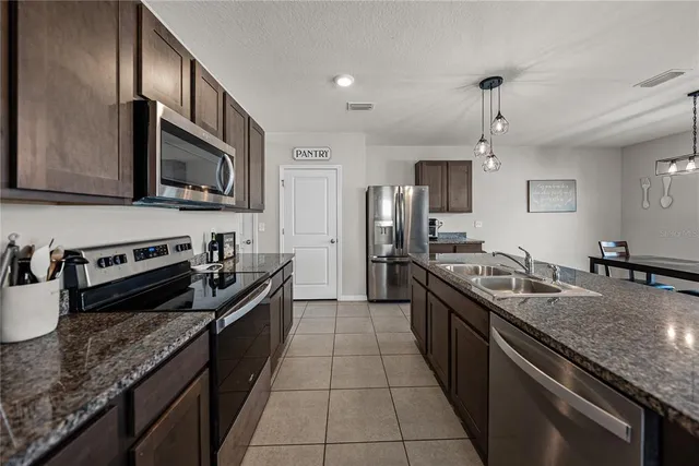 a kitchen with kitchen island granite countertop a sink and a stove