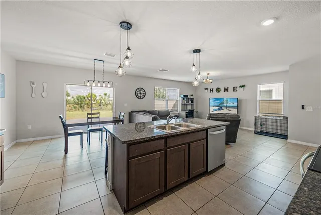 a living room with stainless steel appliances kitchen island granite countertop furniture and a kitchen view