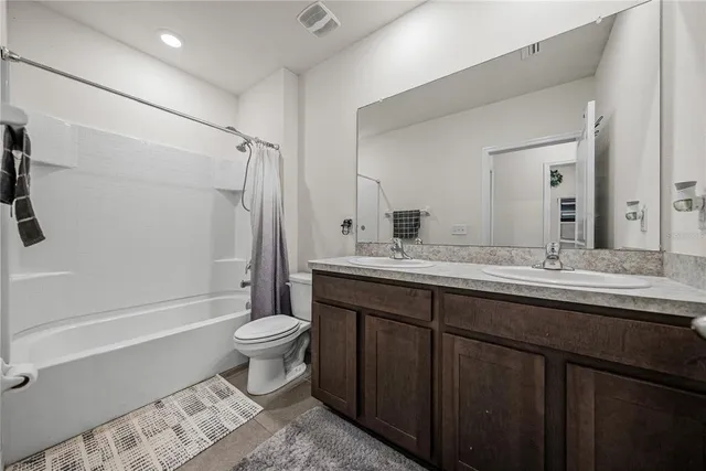 a view of a white house with a small yard and potted plants