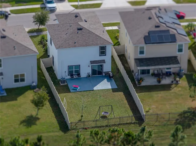 an aerial view of a house with a swimming pool yard and outdoor seating