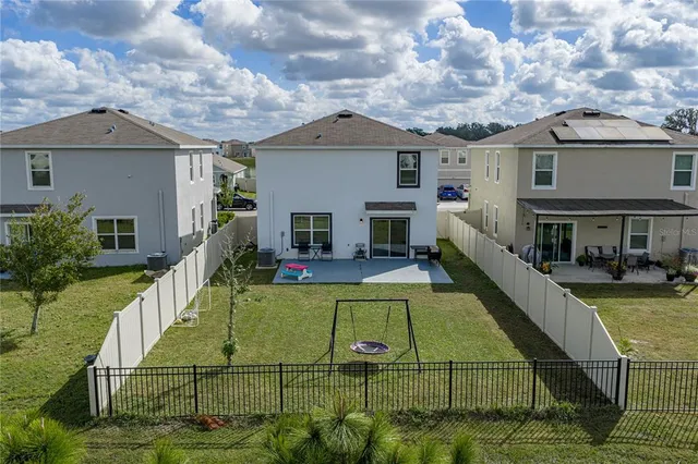 a view of a house with pool and chairs