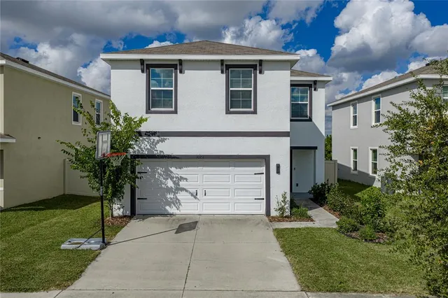 a front view of a house with a garden and plants