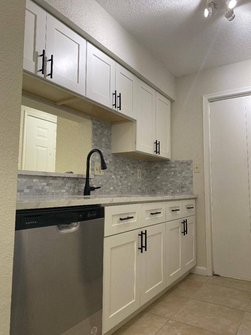 755 Riverside Drive, Unit 1337 Coral Springs, FL 33071 - Photo 11 of 37 a kitchen with granite countertop white cabinets and a sink