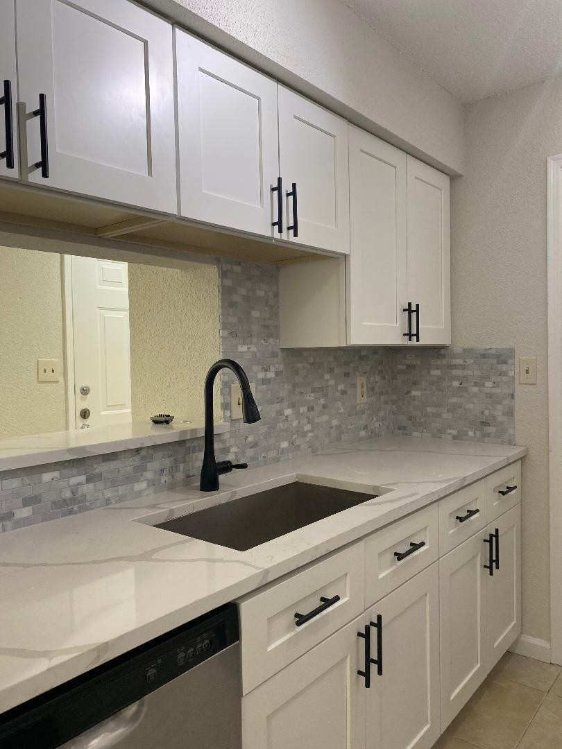 755 Riverside Drive, Unit 1337 Coral Springs, FL 33071 - Photo 13 of 37 a kitchen with white cabinets a sink and dishwasher