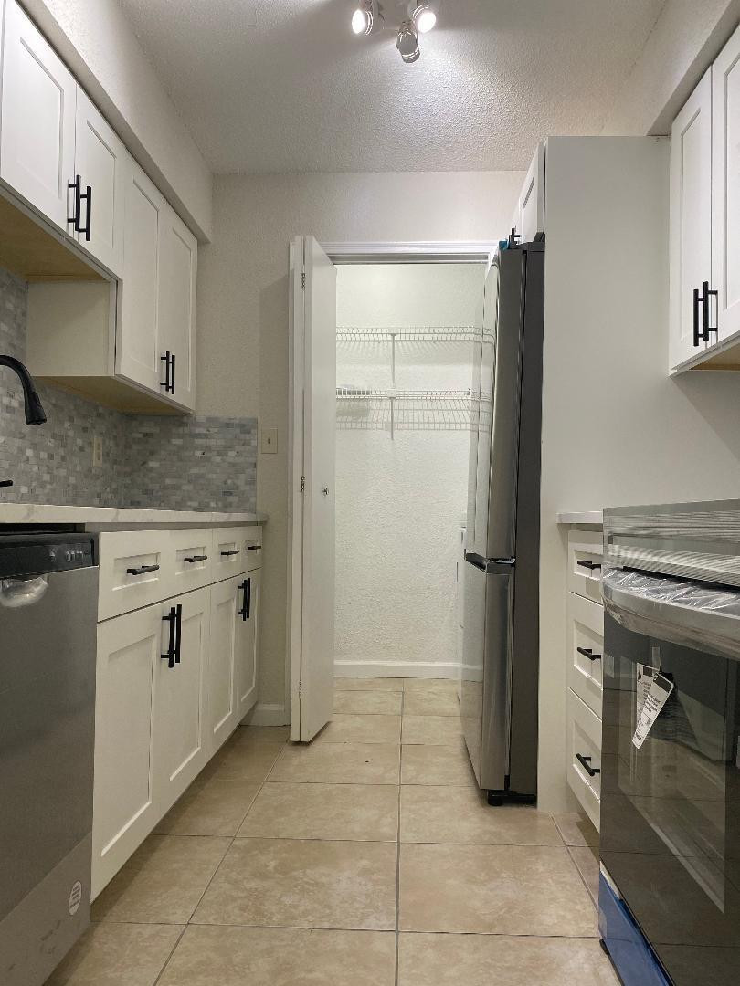 755 Riverside Drive, Unit 1337 Coral Springs, FL 33071 - Photo 17 of 37 a kitchen with a stove and a refrigerator