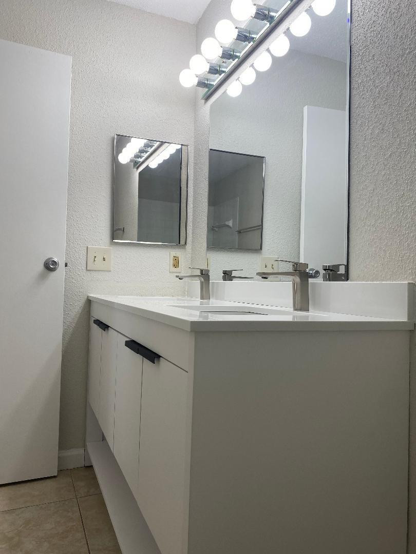 755 Riverside Drive, Unit 1337 Coral Springs, FL 33071 - Photo 30 of 37 a bathroom with a sink and a mirror