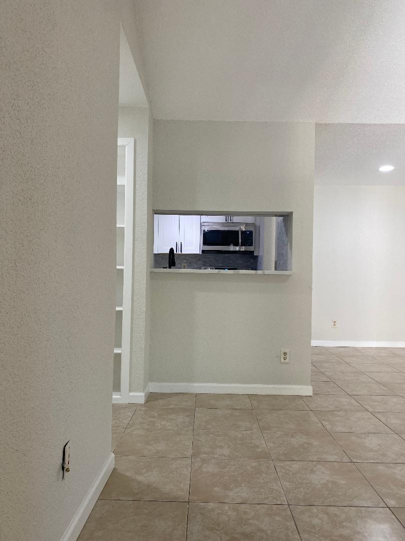 755 Riverside Drive, Unit 1337 Coral Springs, FL 33071 - Photo 3 of 37 a view of a kitchen with microwave and cabinets