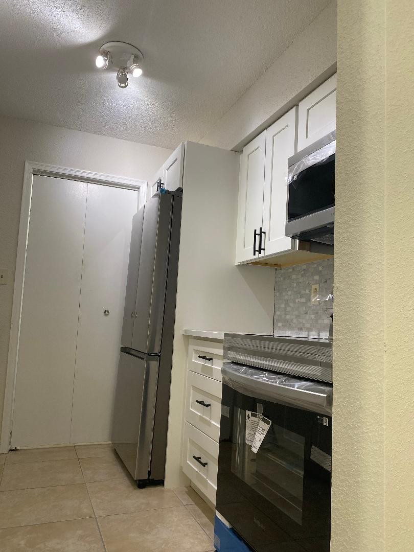 755 Riverside Drive, Unit 1337 Coral Springs, FL 33071 - Photo 9 of 37 a kitchen with a refrigerator and a stove top oven