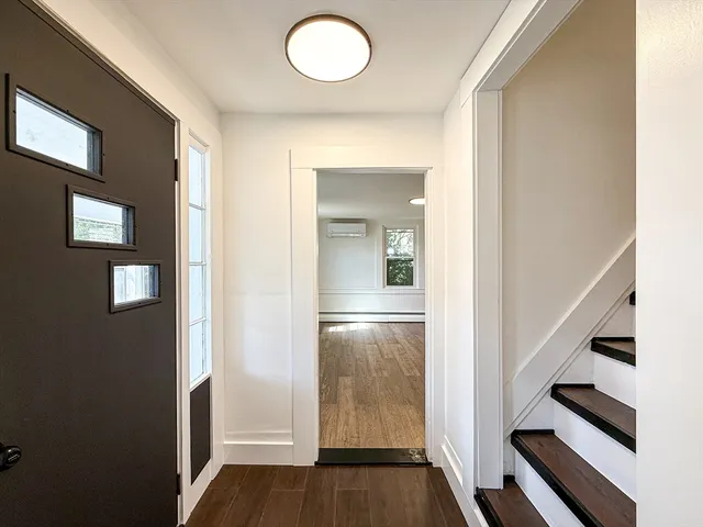 an empty room with wooden floor and staircase