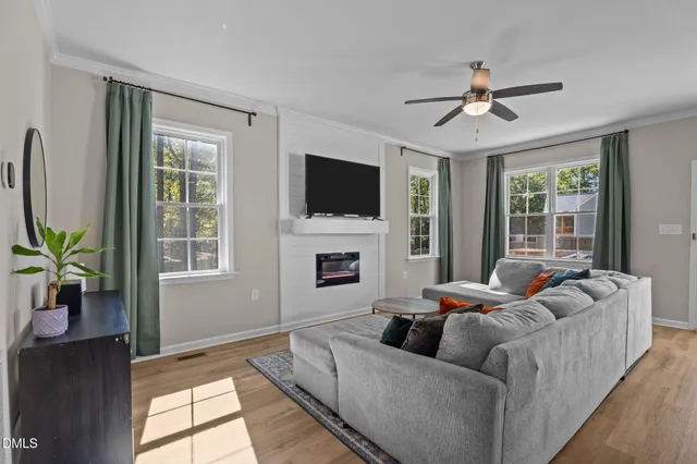 a living room with furniture a fireplace and a flat screen tv