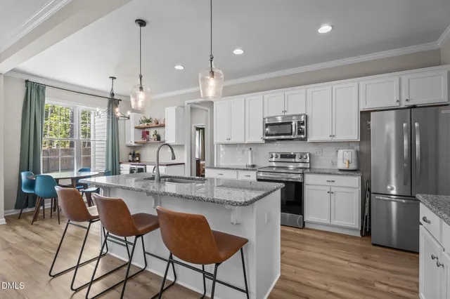 a kitchen with refrigerator cabinets dining table and chairs