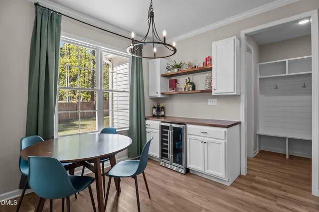 a kitchen with kitchen island a dining table chairs and a wooden floor