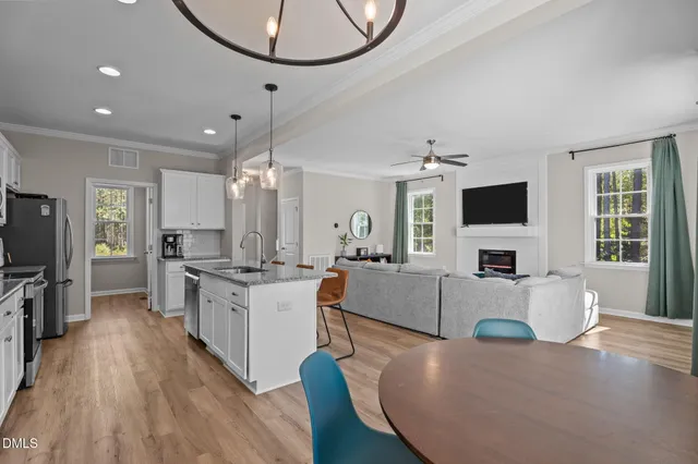 a large kitchen with stainless steel appliances granite countertop a stove and a wooden floors