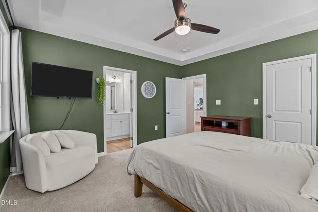 a bedroom with a bed couch and a ceiling fan