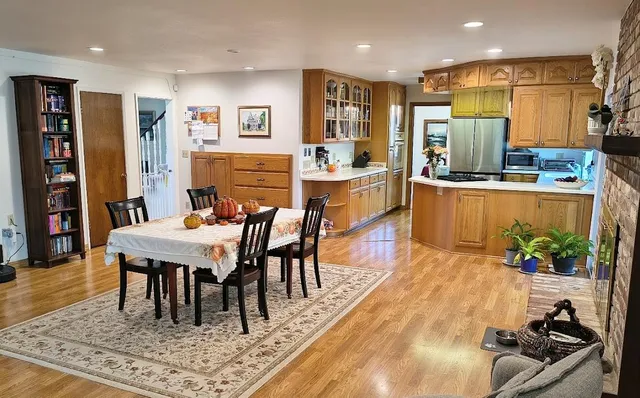 a dining hall with stainless steel appliances granite countertop a dining table and chairs with wooden floor