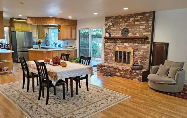 a dining room with furniture a rug and kitchen view