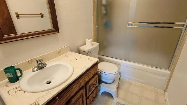 a bathroom with a sink mirror vanity and toilet