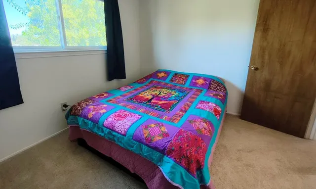 a bedroom with a bed and a window