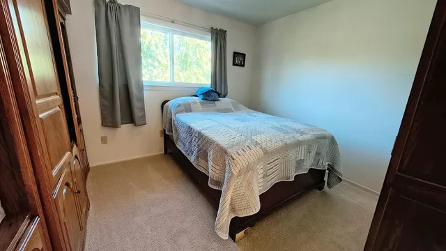 a bed sitting in a bedroom next to a window