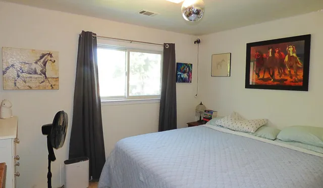 a bedroom with a bed and a painting on the wall