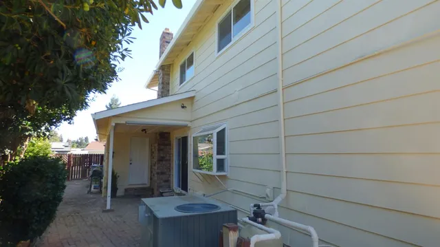 a view of house with backyard and furniture