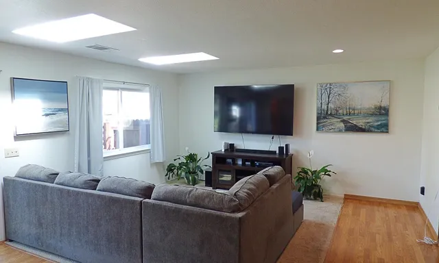 a living room with furniture a flat screen tv and a potted plant