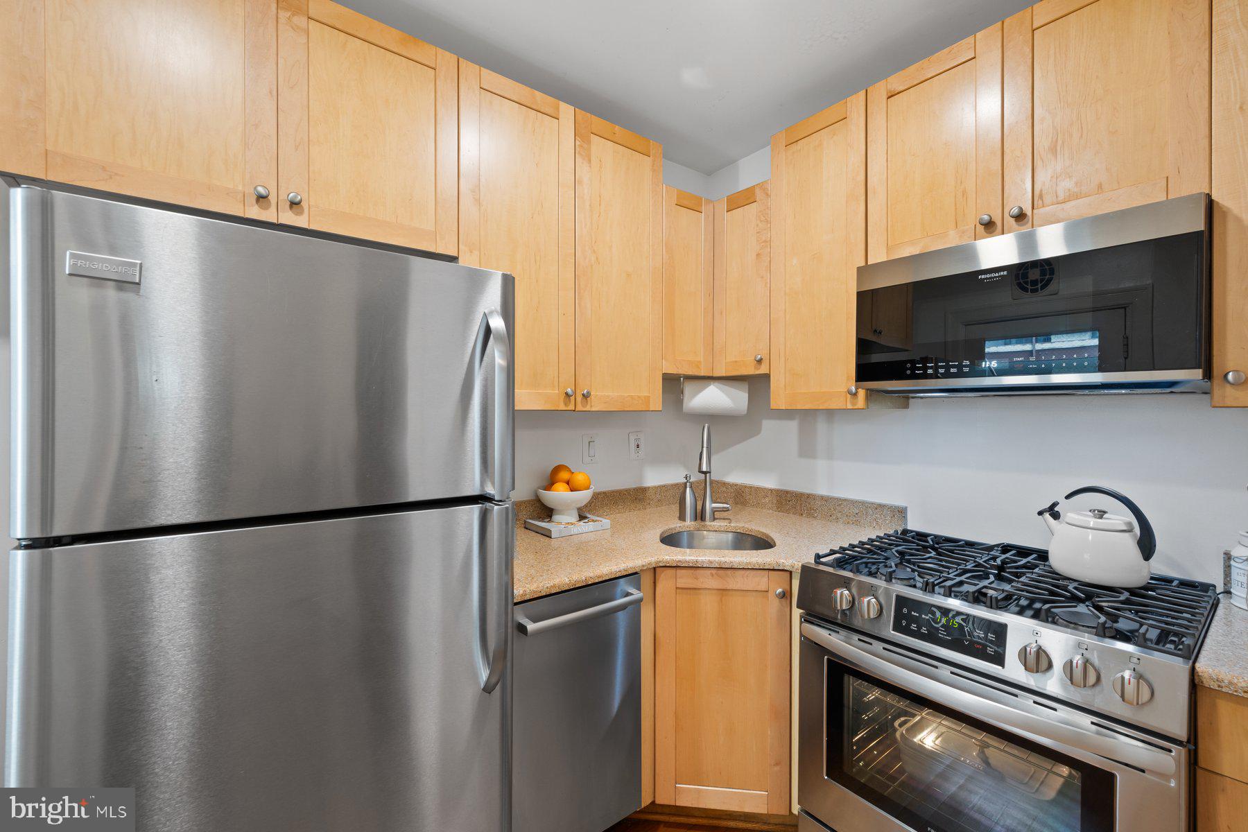 3020 Dent Place Northwest, Unit 30W Washington, DC 20007 - Photo 13 of 37 a kitchen with stainless steel appliances granite countertop a refrigerator stove and microwave