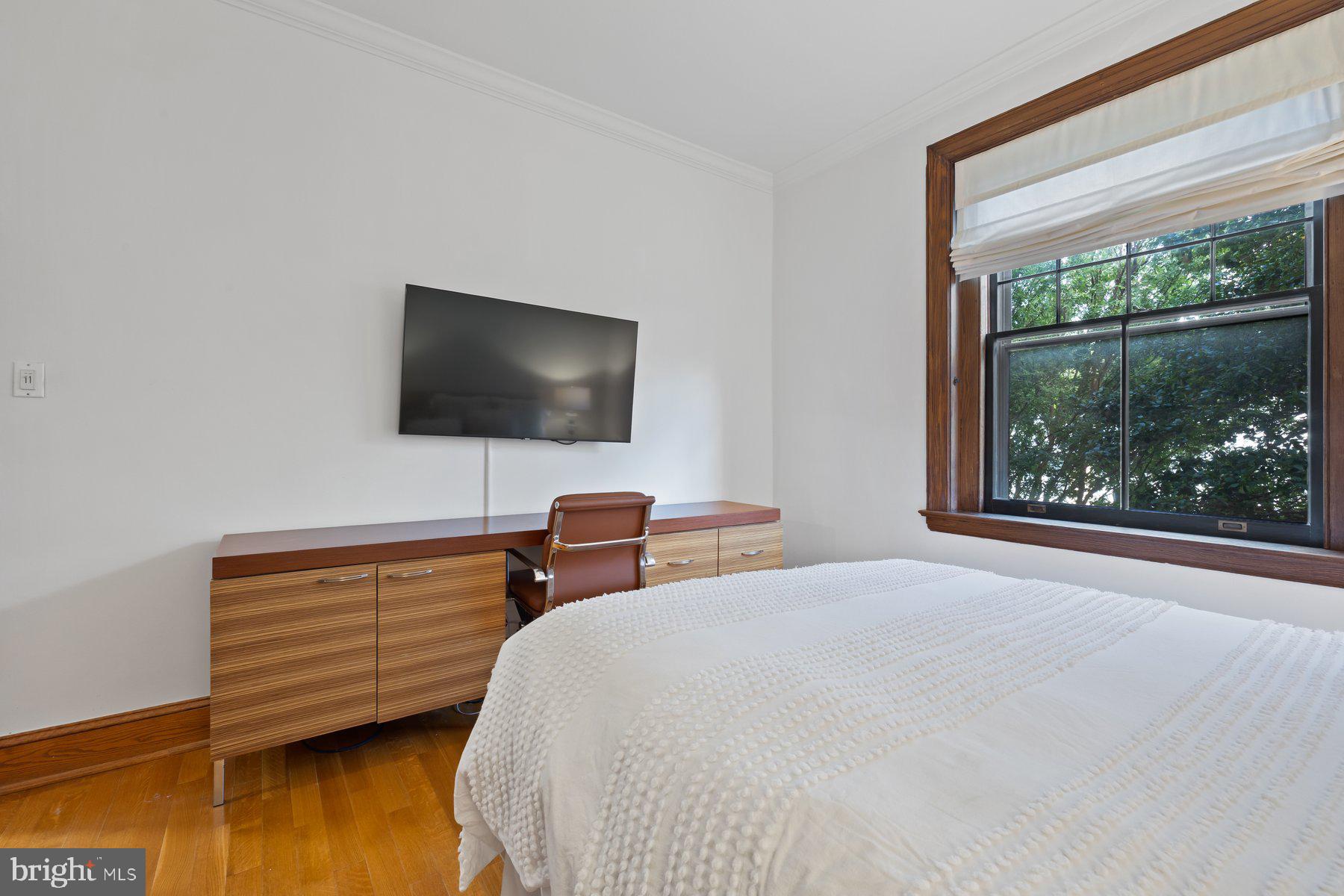 3020 Dent Place Northwest, Unit 30W Washington, DC 20007 - Photo 21 of 37 a bedroom with a bed and a flat tv screen on dresser