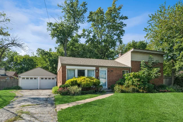 a view of a house with a yard and potted plants