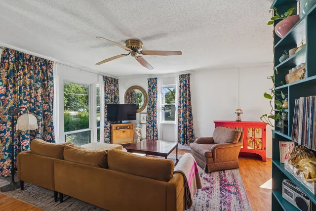 a living room with furniture a fireplace and a large window