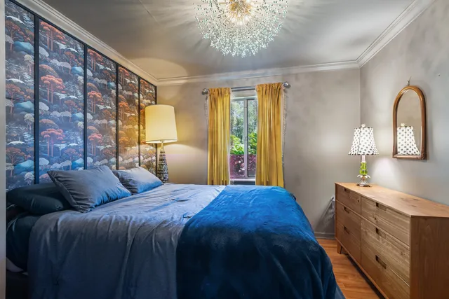 a bedroom with a bed windows and wooden floor