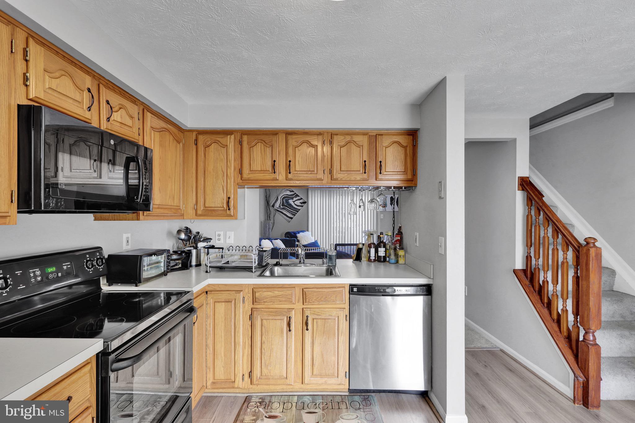 2235 Riding Crop Way Windsor Mill, MD 21244 - Photo 7 of 29 a kitchen with stainless steel appliances a sink stove refrigerator and cabinets