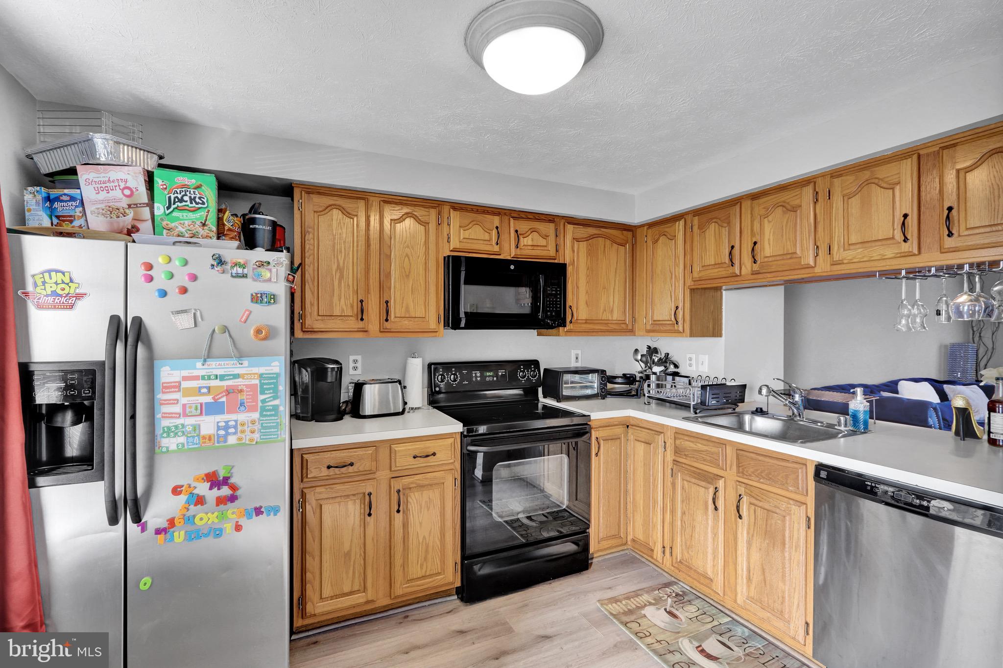 2235 Riding Crop Way Windsor Mill, MD 21244 - Photo 8 of 29 a kitchen with stainless steel appliances a stove a sink dishwasher a refrigerator and cabinets with wooden floor