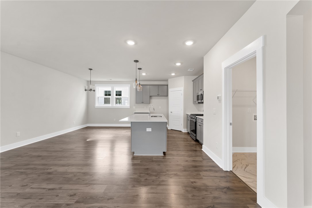 167 Tiger Lily Drive Anderson, SC 29621 - Photo 7 of 34 A contemporary open-concept space features warm wood flooring and a sleek kitchen with a central island.
