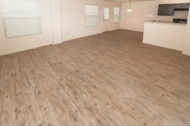 a view of empty room with wooden floor