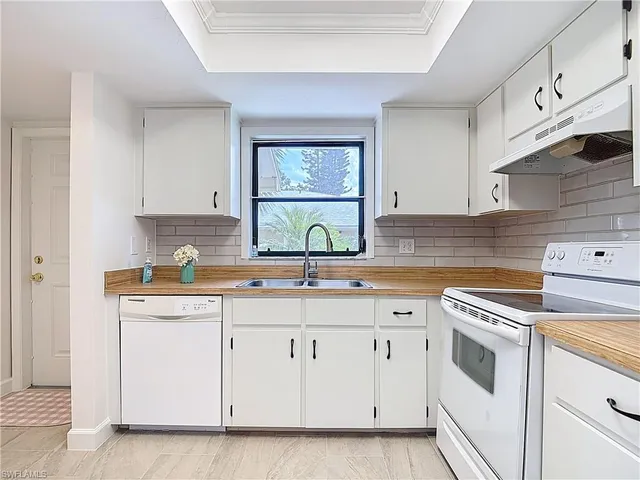 a kitchen with cabinets appliances a sink and a window