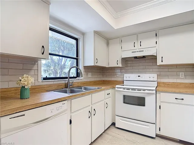 a kitchen with white cabinets and white appliances