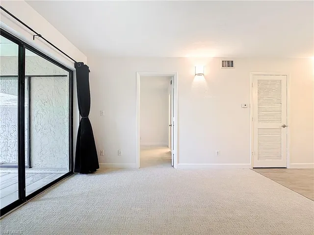 an empty room with a bathroom and a shower