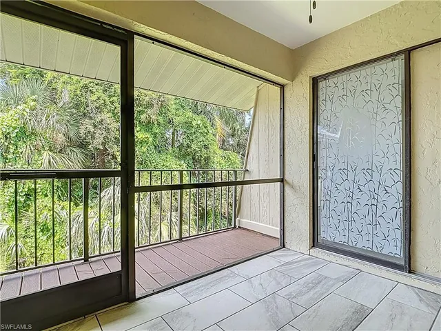 a view of a hallway with wooden floor and a bathroom