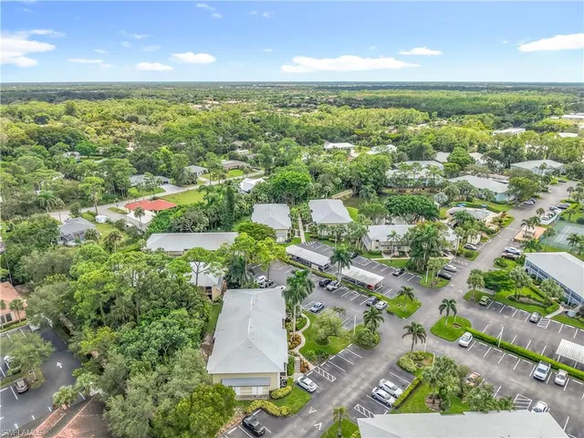 an aerial view of residential houses with outdoor space and trees