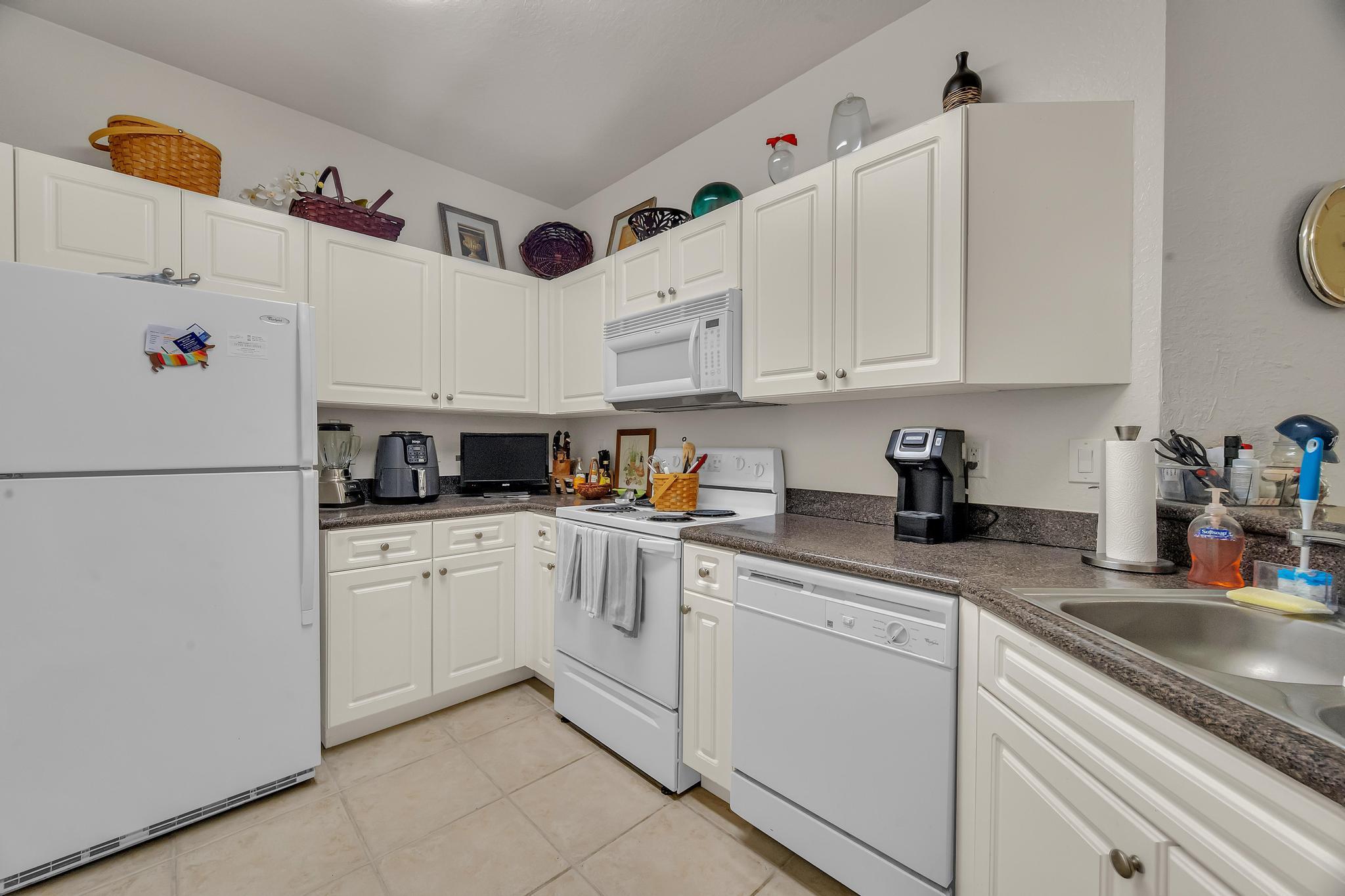 367 Southeast Rogers Court Stuart, FL 34994 - Photo 9 of 35 a kitchen with granite countertop white cabinets and white appliances