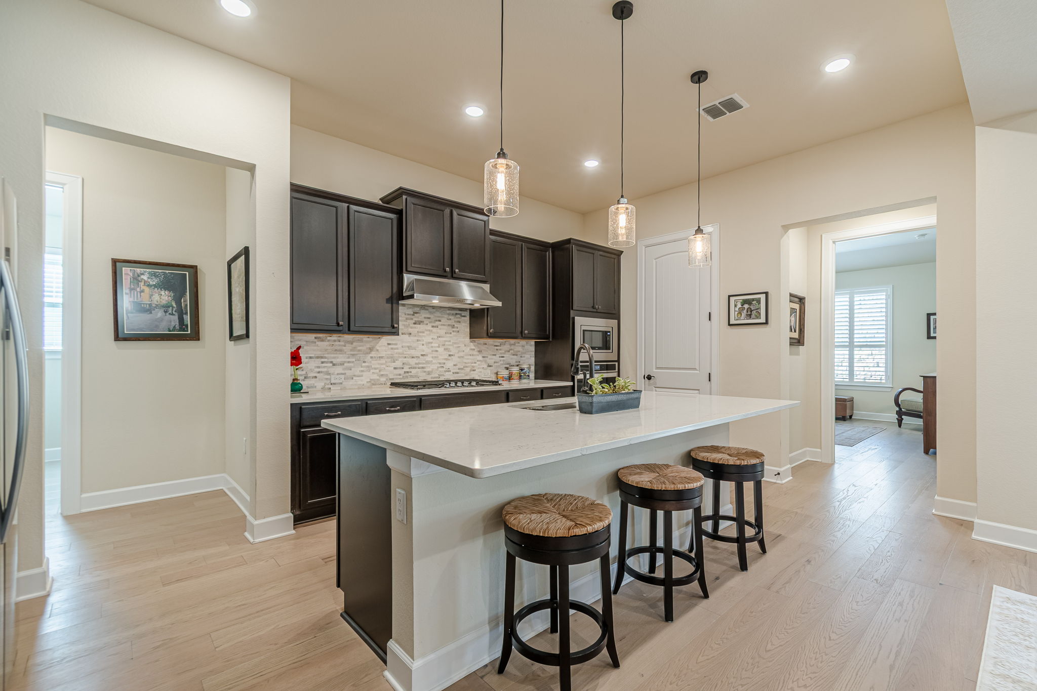 136 Calming Agave Way San Marcos, TX 78666 - Photo 13 of 40 a kitchen with kitchen island a stove a table and chairs